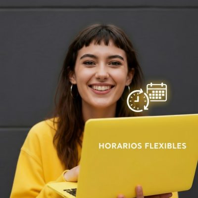 Mujer joven sonriendo felizmente con un portátil amarillo mostrando iconos de reloj y calendario, representando la flexibilidad de horarios en cursos de inglés.